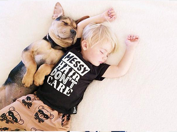 بالصور.. علاقة صداقة قوية تجمع طفل وكلبه تظهر أثناء نومهما